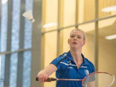 Badmintonspielerin jagt Ball